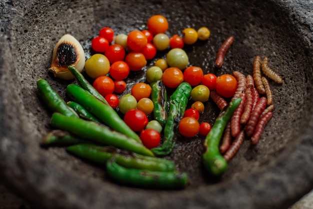 Gros plan de piments de légumes et de vers comestibles pour sauce traditionnelle dans un molcajete