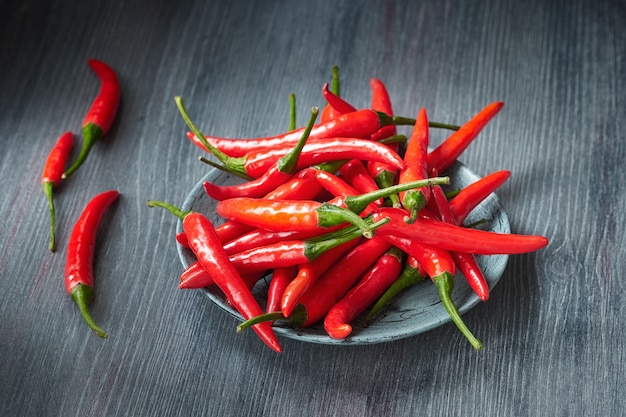 Gros plan sur les piments rouges sur une table en bois foncée