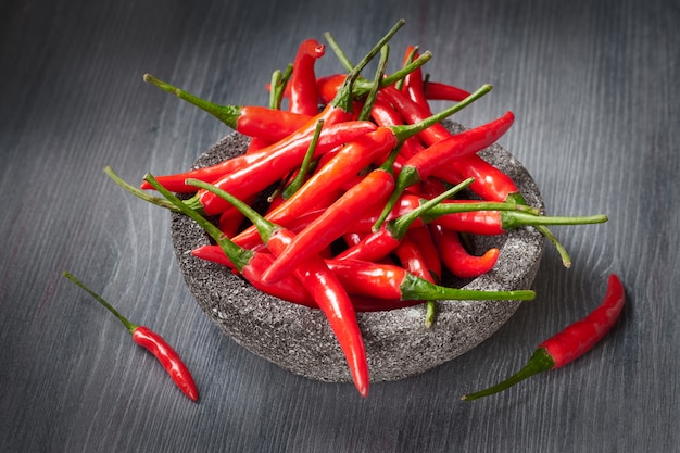 Gros plan sur les piments rouges sur une table en bois foncée