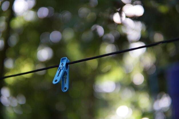 Photo un gros plan d'une pince à linge bleue accrochée à une corde