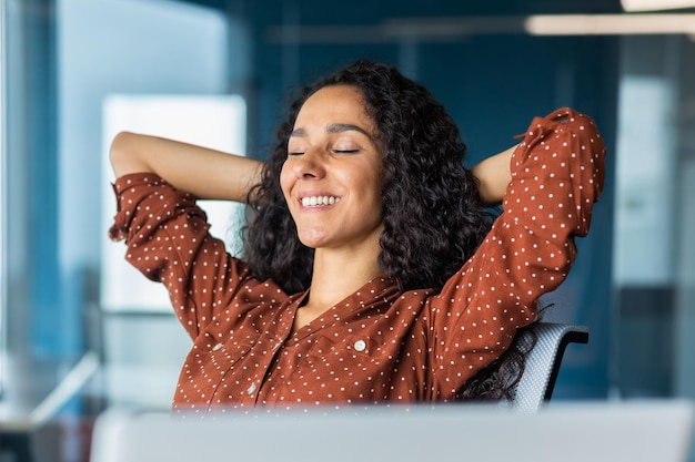 Gros plan pjoto une belle jeune femme d'affaires latino-américaine est assise au bureau à une table avec un