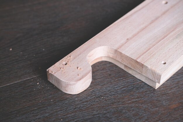Gros plan de planches de bois pour l'assemblage de meubles artisanaux après avoir percé un trou