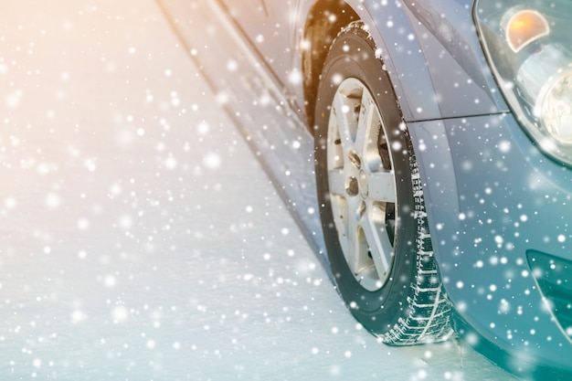 Gros plan sur les pneus en caoutchouc des roues de voiture dans la neige profonde de l'hiver. Concept de transport et de sécurité.