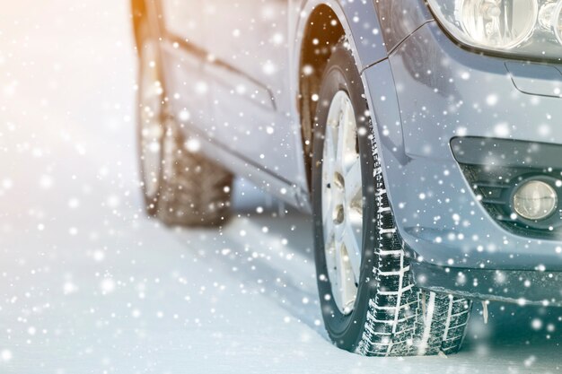 Gros plan sur les pneus en caoutchouc des roues de voiture dans la neige profonde de l'hiver. Concept de transport et de sécurité.