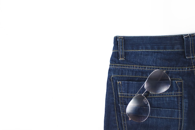 Gros plan de poche de jeans avec des lunettes de soleil. Lunettes de soleil dans une poche arrière d'un jean.