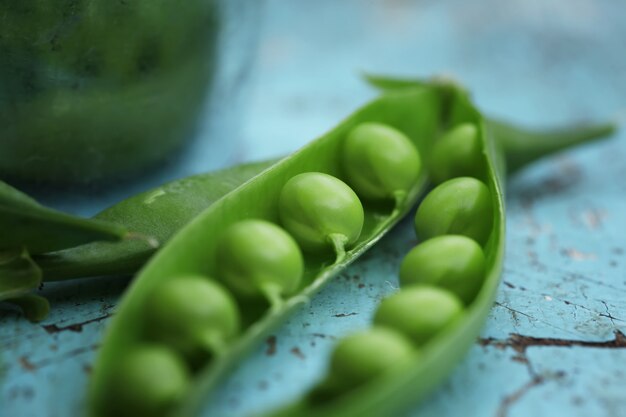 Gros plan de pois vert frais sur un fond en bois bleu