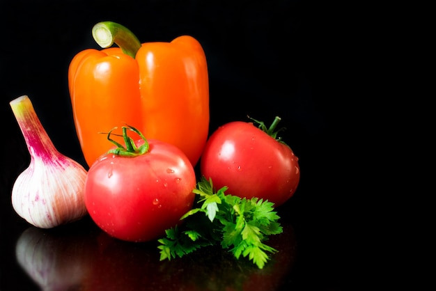 Un gros plan d'un poivron rouge à côté d'un tas de légumes