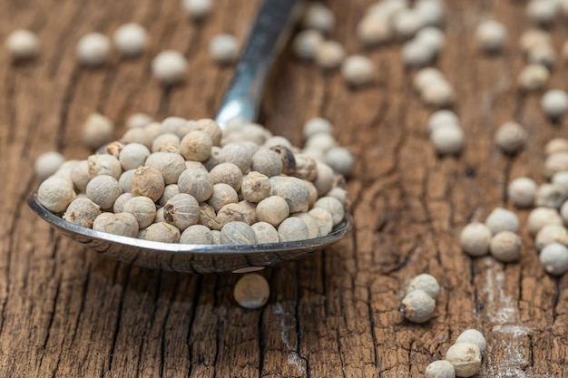 Gros plan de poivrons blancs sur une cuillère sur une table en bois