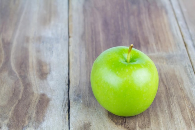 Gros plan d'une pomme verte sur une table en bois