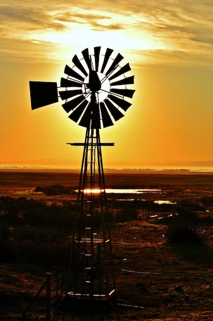 Gros plan avec une pompe à eau Windmill à un beau lever de soleil