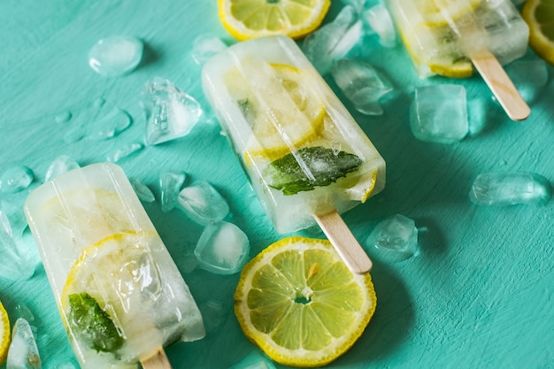 Photo gros plan de popsicles de citron frais sur fond turquoise