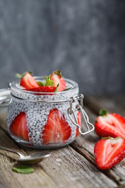 Gros plan d'une portion de pudding de chia avec des fraises fraîches sur des planches en bois Le concept d'aliments sains et biologiques Copier l'espace