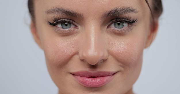 Gros plan portrait d'une belle jeune femme souriante sur fond gris Belle femme caucasienne avec une peau saine naturelle Portrait de beauté femme