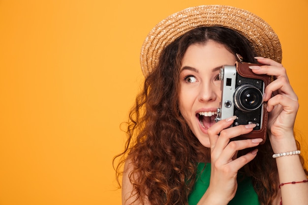 Gros plan le portrait d'une fille aux cheveux bouclés portant un chapeau