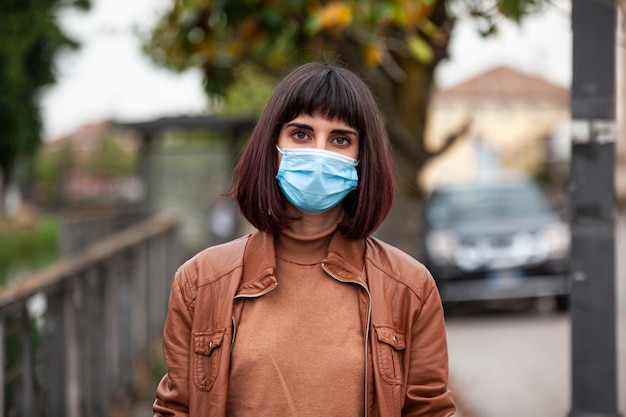 Gros plan Portrait d'une fille avec un masque médical en plein air pendant la quarantaine covid en Italie