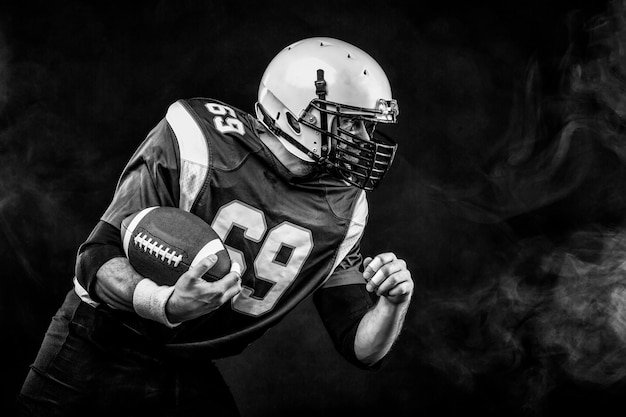 Photo gros plan portrait joueur de football américain barbu sans casque avec le ballon dans ses mains concept football américain patriotisme libre