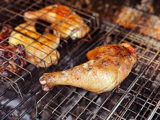 Gros plan sur des poulets grillés en feu