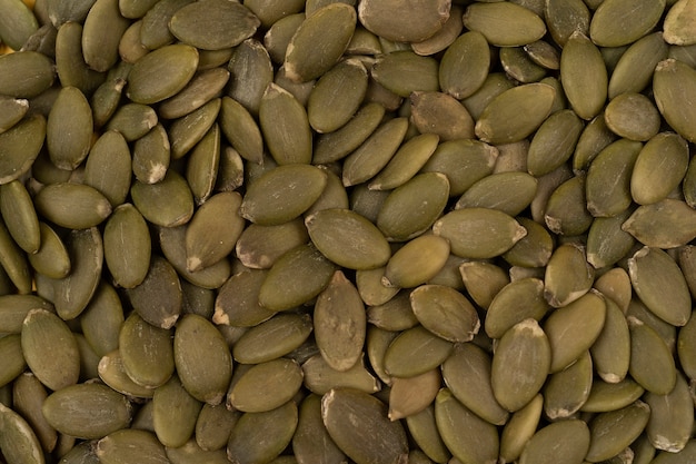 Gros plan de la pousse macro de graines de citrouille sur une vue à plat des graines de citrouille empilées vertes