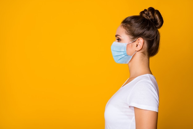 Gros plan profil vue de côté portrait d'elle elle gentille fille portant un masque de gaze de sécurité arrêter la pneumonie grippe contagieuse grippe grippe espace copie affiche affiche isolé fond de couleur jaune vif