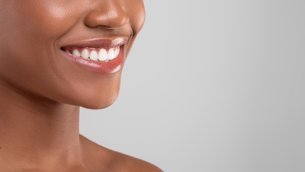 Photo gros plan de publicité dentaire coup de beau sourire de jeune femme noire