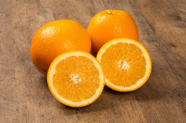 Gros plan de quelques oranges dans un panier sur une surface en bois. Fruit frais.