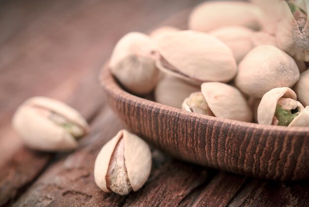 Gros plan de quelques pistaches grillées sur une surface naturelle