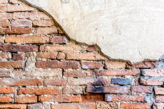 Gros plan et recadrage du ciment de fissure sur fond de mur de briques anciennes