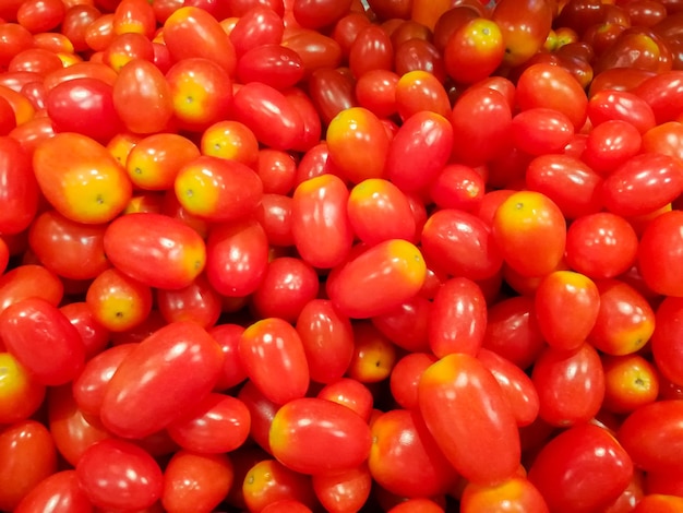 Gros plan et recadrage de tas de petites tomates adaptées à l'arrière-plan de l'écran