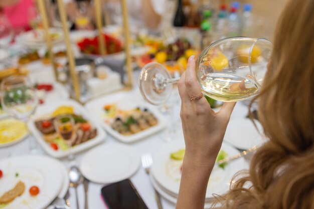 Gros plan recadré de la table lors d'un dîner romantique avec les mains de l'amant avec des verres de vin et de nourriture.