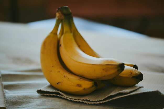 Gros plan d'un régime de bananes sur un fond de tissu sombre