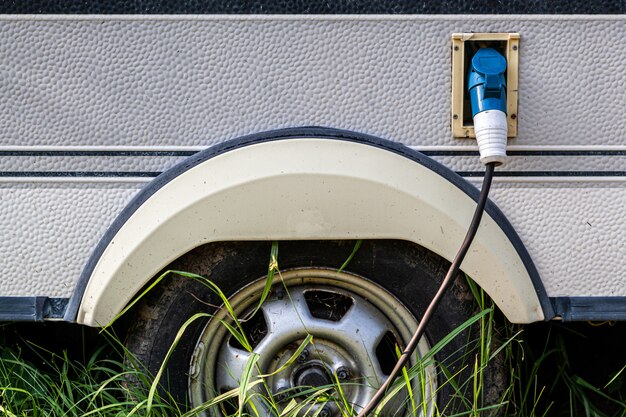 Gros plan d'un réservoir d'essence avec un pistolet inséré pour alimenter en carburant une vieille voiture dans la rue