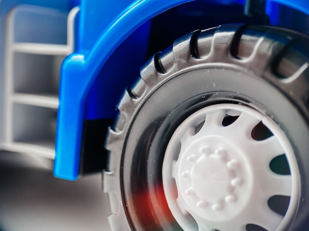 Gros plan sur une roue d'une petite voiture bleue pour enfants. Gros plan sur des jouets et des biens pour enfants.