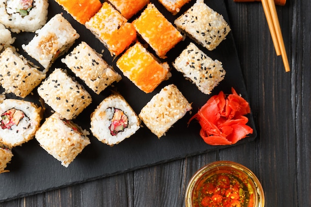 Gros plan de rouleaux de sushi sur plateau noir