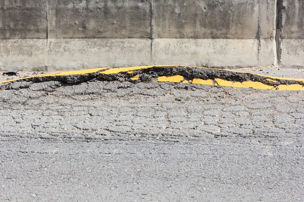 Gros plan d'une route goudronnée fissurée