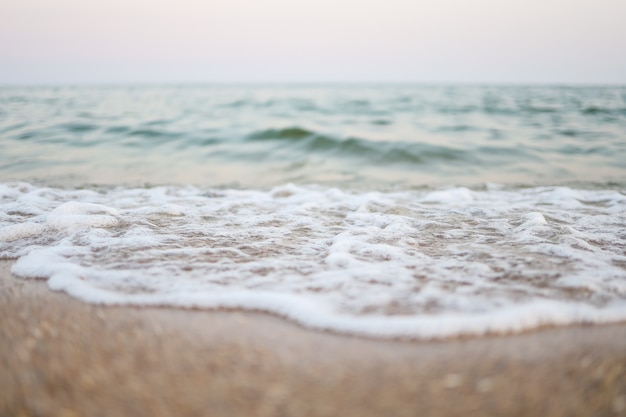 Gros plan sur le sable avec un fond de ciel de mer flou, une journée d'été, un espace de copie ou pour le produit.