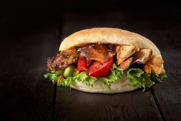 Gros plan d'un sandwich au kebab sur fond en bois