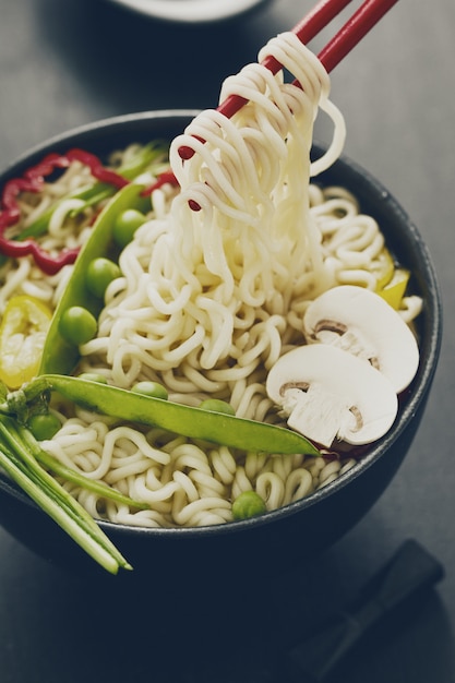 Gros plan de savoureuses assiettes asiatiques aux nouilles aux légumes. Fermer.