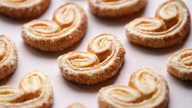 Gros plan de savoureux biscuits sucrés saupoudrés de sucre sur fond rose cuisine maison