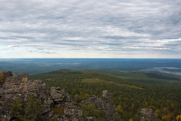 Gros plan des scènes de montagnes dans le parc national Kachkanar, Russie, Europe. Temps nuageux, ciel bleu dramatique, arbres verts lointains. Journée d'été colorée