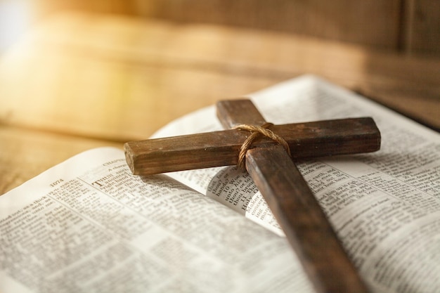 Gros plan d'un simple collier croix chrétienne en bois sur la Bible , ton vintage , dieu