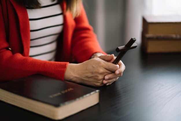 Gros plan d'une simple croix chrétienne en bois sur la Bible Concept d'espoir foi christianisme religion