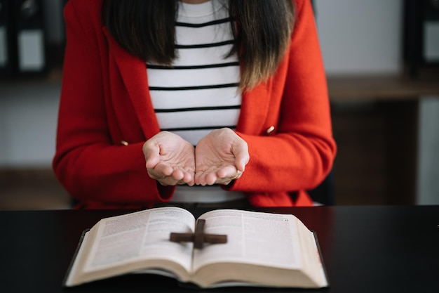 Gros plan d'une simple croix chrétienne en bois sur la Bible Concept d'espoir foi christianisme religion