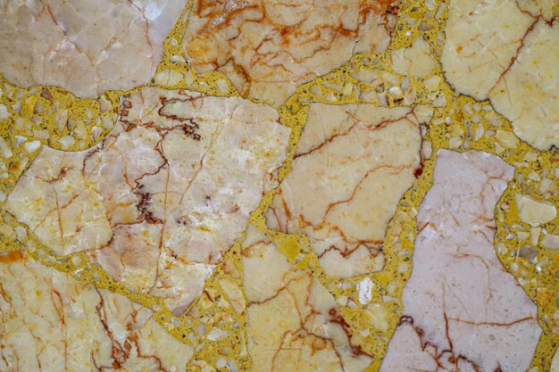 Un gros plan d'un sol en marbre aux couleurs jaune et marron.