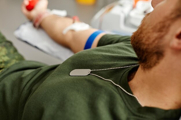 Gros plan d'un soldat faisant un don de sang à l'espace de copie du centre hospitalier