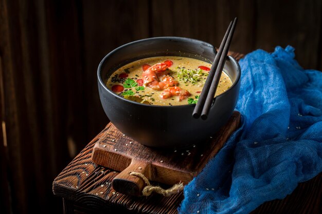 Gros plan de soupe chaude Tom Yum dans un bol noir