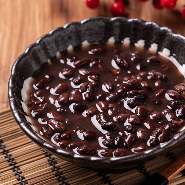 Gros plan de la soupe de haricots rouges adzuki dans un bol sur fond de table en bois pour manger.