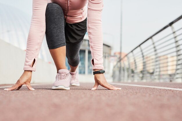 Gros plan sur une sportive en vêtements de sport debout dans une pose, elle participe à des compétitions de course