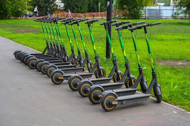 Gros plan de stationnement de scooter électrique. Nouveau moyen de transport populaire pour explorer les villes et les sites touristiques. Transports respectueux de l'environnement.