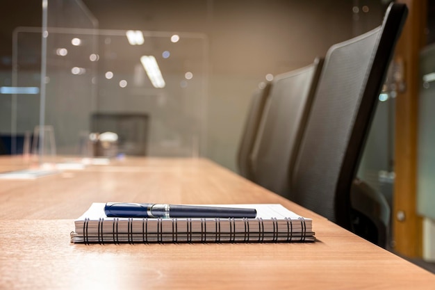 Gros plan sur un stylo et un bloc-notes sur une table dans la salle de réunion