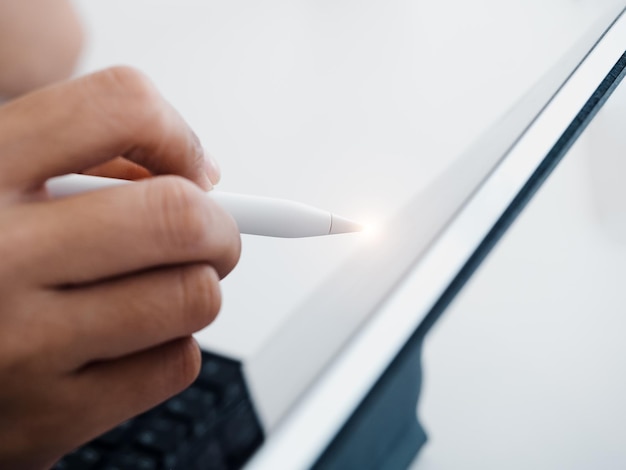 Gros plan stylo électronique blanc ou crayon à la main écrire dessiner ou signer sur un ordinateur à écran de tablette numérique isolé sur fond blanc Concept d'entreprise et de technologie Travailler avec un appareil technologique